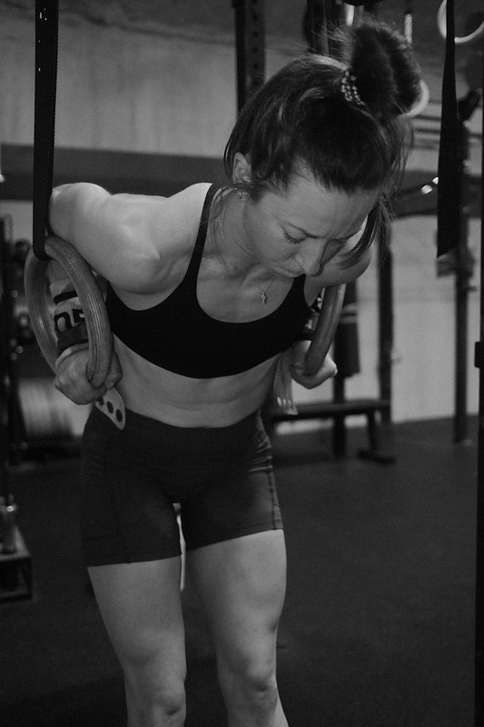 Black and white photograph of an athlete mid dip on gymnastic rings, shot by Jake Mizell, Austin, Texas photographer